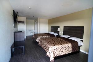 安大略Airport Stay Motel的酒店客房设有两张床和电视。