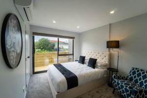 奥克兰Sunnyhills Viewside Town House的一间卧室设有一张床和一个大窗户