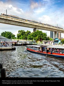 曼谷Nasa Bangkok - SHA PLUS Certified的两艘船在河上桥上的火车