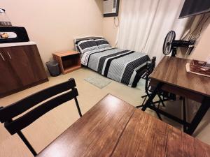 伊洛伊洛C Comfortable Avida Room的客房设有一张床、一张桌子和一张书桌。