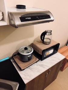 伊洛伊洛C Comfortable Avida Room的厨房柜台配有烤面包机和慢炉灶