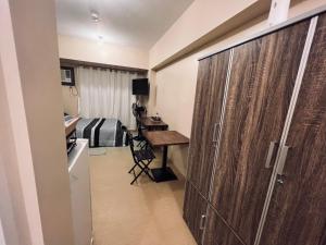 伊洛伊洛C Comfortable Avida Room的酒店客房配有一张床、一张书桌和一个衣柜。