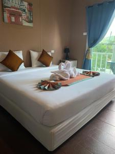 皮皮岛上坡村舍酒店的一张白色大床,上面有毛巾