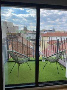 布尔诺VV酒店及公寓的两把椅子坐在阳台,可望见窗外