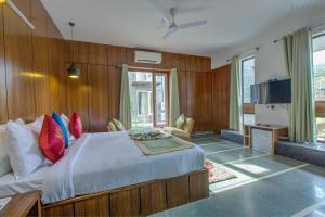 兰纳加The Cloyster Resort and Spa的一间卧室配有一张带红色和蓝色枕头的大床