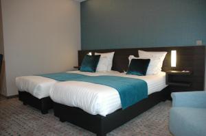 布鲁日Hotel Restaurant Weinebrugge的一间卧室配有一张带蓝白色床单的大床