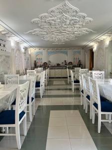 撒马尔罕卡文赛瑞酒店的用餐室配有白色的桌子和白色的椅子