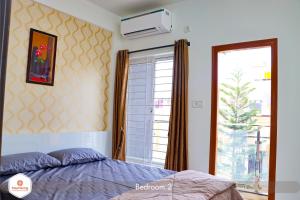 班加罗尔StayMazing Boutique AC Apartments-Manyata,Hebbal-1,2&3 BHKs-30mins to Airport的一间卧室设有一张床和一个大窗户