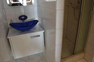 希尔克道夫Meerblick FeWo Nr A-107的浴室配有蓝色水槽和淋浴。