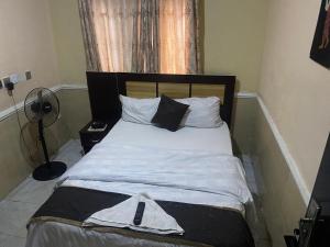 伊洛林Belmorris Hotel的卧室内的一张带白色床单和枕头的床