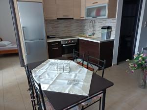 米蒂利尼studio apartment KAMARES的一间带桌子和冰箱的小厨房