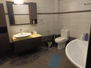 米蒂利尼studio apartment KAMARES的浴室配有盥洗盆、卫生间和浴缸。