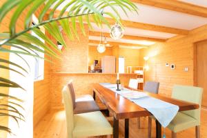 KusumotoAwaji Seaview Resort in Nojima的一间带木桌和椅子的用餐室
