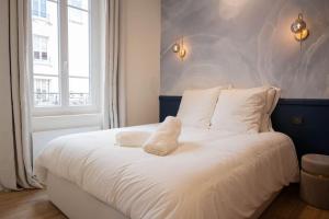 维希Villa La Roseraie的卧室内的一张带白色床单和枕头的床