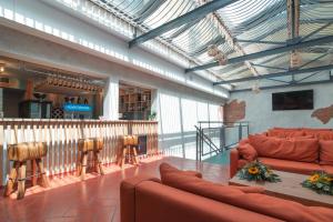 因普鲁内塔Villa Cesi Resort & Spa的大堂设有红色沙发,酒吧设有凳子