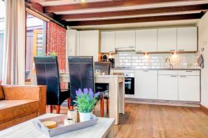 StavenisseZeeuwse Rust Stavenisse的厨房以及带白色橱柜和桌子的客厅。