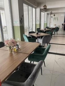 霍雷祖Hotel Maya的餐厅设有木桌和绿色椅子