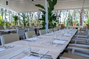 因普鲁内塔Villa Cesi Resort & Spa的餐厅里一张长桌子和白色的桌椅