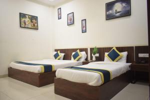 印多尔Hotel Lakshya Sheesh Mahal Indore的两间带两张床的酒店客房