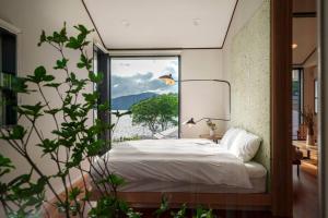 元箱根プライベートリゾート芦ノ湖的一间卧室设有一张床和一个大窗户