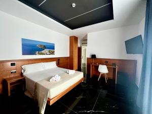 普拉亚·阿马勒Hotel TEA - Praia a Mare的一间卧室配有一张床,上面有两条毛巾