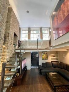 伦敦4 floor Apartment in Covent Garden的带沙发和玻璃楼梯的客厅