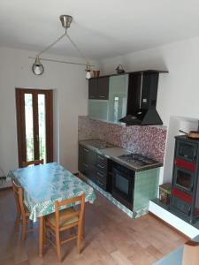 波焦莫亚诺Casa Mia的厨房配有桌子和炉灶。 顶部烤箱