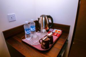 亚喀巴ِAfnan hotel的茶壶和桌子上的瓶装水托盘