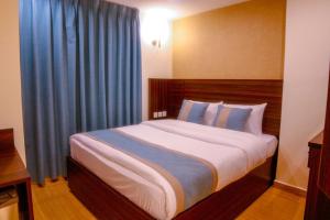 亚喀巴ِAfnan hotel的一间卧室配有一张带蓝色窗帘的大床
