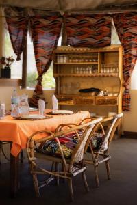 MtowabagaLake Natron Maasai giraffe eco Lodge and camping的一张桌子、两把椅子和一张桌子及一张桌布