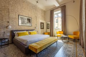 卢卡Grand Universe La Residenza的一间卧室配有一张特大号床和黄色枕头