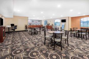 Marysville马里斯维尔速8汽车旅馆的一间铺有地毯并配有桌椅的用餐室