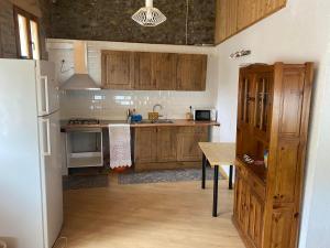 ArfaCasa Casteller 1-4 huéspedes的厨房配有木制橱柜、桌子和冰箱。