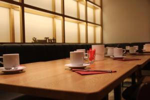 慕尼黑慕尼黑青年CVJM酒店的一张长木桌,上面有杯子和餐巾