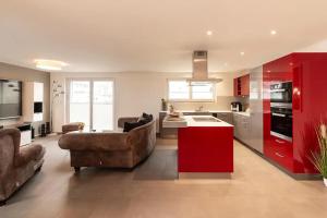 施泰因Luxus 3,5 Zi-Whg 128m2, 8 Min zum See & Altstadt的带沙发的客厅和红色厨房。
