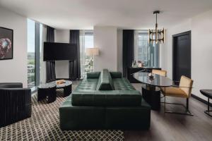 奥斯汀Thompson Austin, by Hyatt的客厅配有绿色沙发和桌子