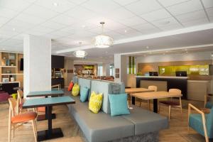 魁北克市Home2 Suites By Hilton Quebec City的一个带桌椅的大堂和一间自助餐厅