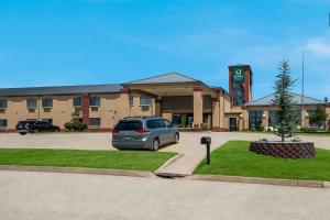 爱德蒙Quality Inn & Suites Oklahoma City North的停在大楼前停车场的汽车