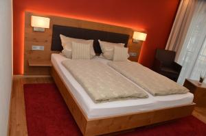 特里滕海姆赛米纳斯霍夫旅馆的一间卧室配有一张带橙色墙壁的大床
