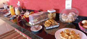 卡皮托利乌Pousada Morada dos Pássaros的自助餐,包括面包和糕点在柜台