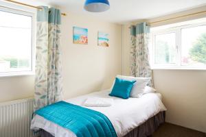 霍尔斯沃西The Barn (Chilsworthy), 6 Sleeper House, 19 Min Drive into Bude, Cornwall的一间卧室配有一张带蓝色和白色枕头的床