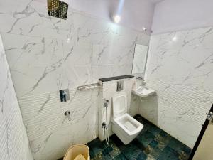 印多尔Hotel Kiwi Inn的白色的浴室设有卫生间和水槽。