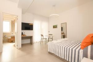 维耶斯泰Agorà Vieste Rooms & Apartments的白色卧室配有床和桌子