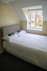 ChurchdownLuxe Cosy&Spacious 2 Bed House - Super Fast Wi-Fi & Private Parking Near GLO Airport & Cheltenham Racecourse的卧室配有一张大白色床和窗户