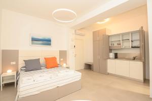 维耶斯泰Agorà Vieste Rooms & Apartments的一间带大床的卧室和一间厨房