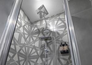 伊斯坦布尔Monezza Hotel Maltepe的带淋浴的浴室(带瓷砖墙)