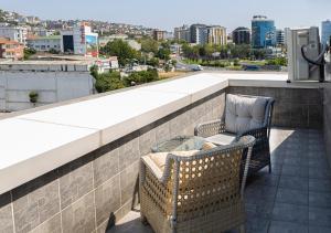 伊斯坦布尔Monezza Hotel Maltepe的大楼内的阳台配有两把椅子和一张桌子