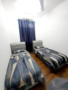 波德申CASARIA HOMESTAY PD 3Bedrooms Bungalow House的两张睡床彼此相邻,位于一个房间里
