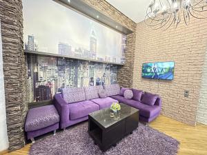 巴库Sahil Lux的客厅配有紫色沙发和电视