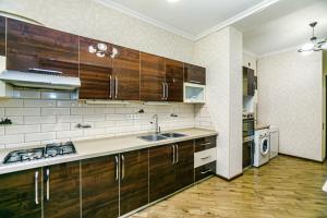 巴库Apartment Lux的一个带木制橱柜和水槽的厨房